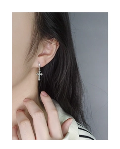 Primo piano di orecchini a cerchio con croce in argento e micro-zirconi incastonati