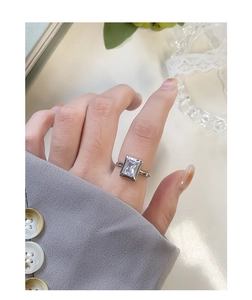 Detail of S925 sterling silver ring with emerald cut zircon worn on hand for office style