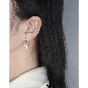 Orecchini a cerchio con croce in argento e zircone su modella per un look di tendenza