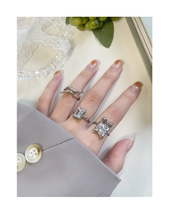 Detailed view of three silver rings with clear zircon stones on a female hand