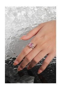 Macro view of a polished silver ring featuring a large heart-shaped pink gemstone inlay