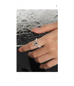 Detail of S925 silver ring featuring heart lock pendant and pearl chain on hand
