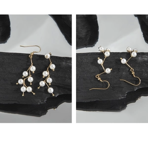 Macro detail of S925 silver pearl drop earrings with elegant golden branch design