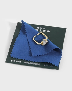 Macro view of a gold square ring with triangle zircon and blue silver polishing cloth