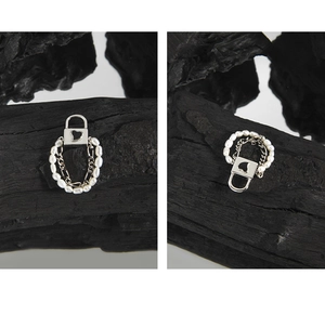 Detail of silver heart locket ring with fine white pearls on a charcoal background