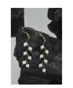 Close-up of S925 silver fringe drop earrings with white pearls on a gold wire