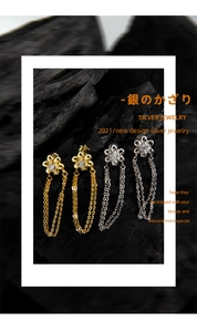 Detail of floral drop earrings with long tassels in gold and silver finishes