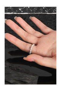 Detail of S925 silver double-layer ring with natural pearls and metal chain on finger