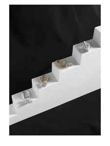Macro view of geometric crystal earrings with silver and gold finish in a luxury display