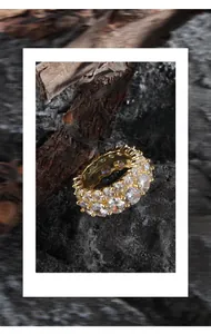 Detailed view of a gold double-layer zircon ring on natural bark and rock background