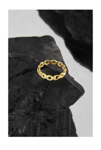 Macro detail of gold chain link ring with sparkling zircon inlay on black charcoal