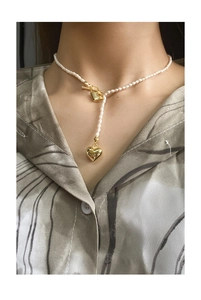 Detail of vintage heart and lock pearl necklace with OT clasp on model neck