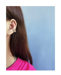 Detail of S925 silver ear cuff with olive green zircon gemstone on ear bone area