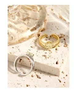 Detail of adjustable double-layer rings with square-cut yellow zircon in gold and silver