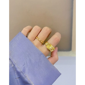 Minimalist gold chain and lava texture ring set with diamonds on a purple shirt cuff