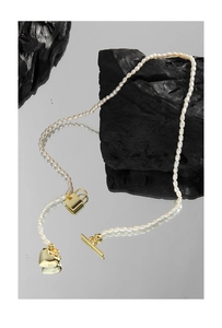 Detailed macro of S925 silver pearl necklace with gold heart lock and OT buckle charm