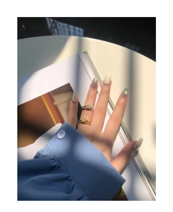 Detail showing stacked S925 silver rings with square olive green zircon on female hand