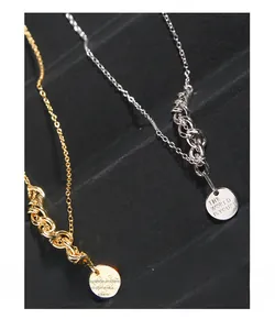 Detailed shot of gold and silver coin pendants engraved with THE WORLD IS YOURS text