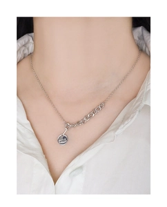 Detail of silver S925 necklace featuring an engraved round tag with mixed chain style