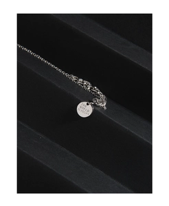 Detailed shot of S925 silver coin pendant engraved with THE WORLD IS YOURS on black stand