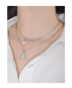 Detail of S925 silver layered necklace featuring a teddy bear charm and round disc pendant