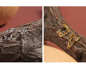 Macro detail of S925 sterling silver chain earrings in gold and silver on wood