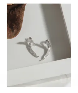 Macro shot of S925 sterling silver feather earrings with micro-inlaid zircon details