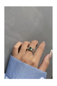 Macro view of S925 silver ring featuring emerald-cut green zircon and polished band