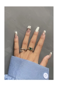 Detail of S925 silver ring set with emerald cut green zircon on female hand