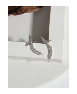 Detailed view of silver feather earrings with micro-paved zircons on a frame