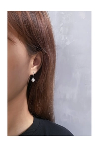 Macro detail of S925 sterling silver hoop earrings with shimmering disco ball crystal pendant