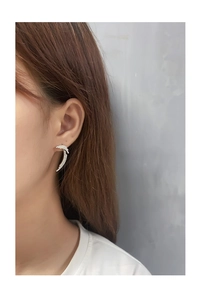 Close-up of S925 silver feather earrings with micro-pave cubic zirconia on a model