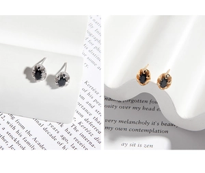 Gros plan de boucles d'oreilles ovales en zircon noir avec bases en argent et or
