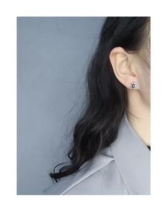 Gros plan sur la boucle d'oreille fleur en argent S925 avec zircon noir ovale central