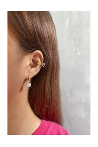 Détail de créoles dorées avec boules en zircone et un large earcuff sur l'oreille