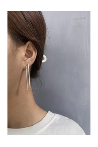 Detail view of S925 silver tassel earrings with shimmering cubic zirconia on model