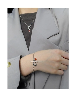 Macro detail of silver necklace and bracelet with red stones and OT buckle clasp