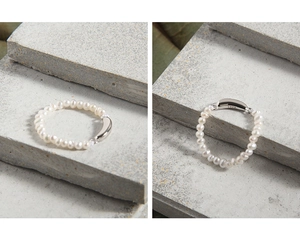 Close-up of minimalist S925 sterling silver stamp on a freshwater pearl ring band