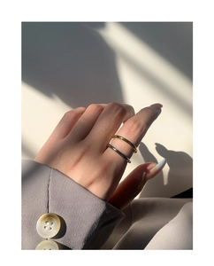 Dettaglio di un set di anelli minimalisti in oro e argento con finitura lucida a specchio