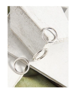 Primo piano di anelli minimalisti in argento sterling S925 su pietra con decoro naturale