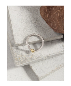 Detail of S925 sterling silver ring with gold sphere on gray matte stone slabs