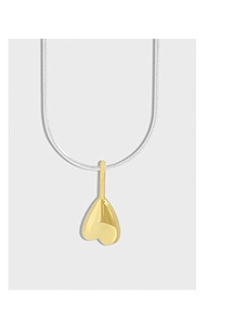 Macro view of a polished two-tone heart pendant with a sleek silver snake chain