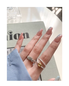 Gros plan de bagues en argent sterling S925 et anneau torsadé avec perle dorée