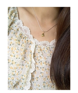 Close-up of a two-tone heart pendant necklace worn on a model for a stylish look