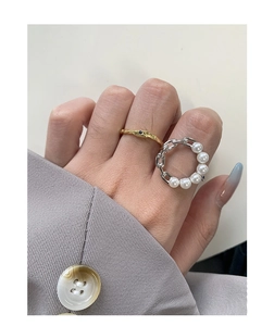 Detail of S925 silver chain ring with white pearls and gold sapphire textured ring