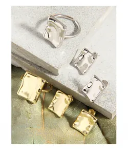 Macro shot of irregular liquid-style square S925 silver rings and studs on stone