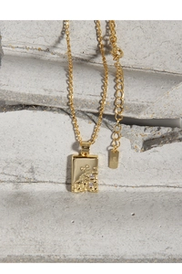 Detailed macro view of S925 sterling silver stamp on golden pendant necklace with zircons
