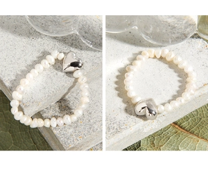 Detailed view of handmade natural pearl ring with polished silver heart charm accessory