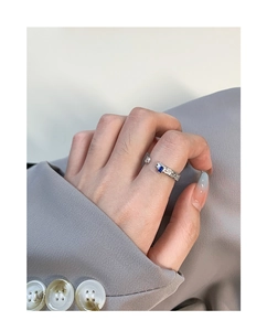Detail of S925 silver ring with hammered texture and blue zircon worn on finger