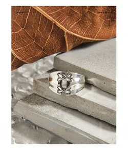 Macro shot of retro S925 silver wide ring featuring a unique lace-up wire design